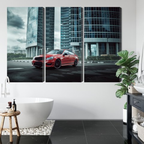 Obraz Wieloczęściowy Czerwony Samochód Na Tle Nowoczesnych Drapaczy Chmur Obraz Wieloczęściowy Czerwony Samochód Na Tle Nowoczesnych Drapaczy Chmur