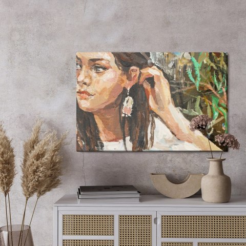 Obraz Na Płótnie A Young Girl Is Sitting In An Ethnic White Dress. The Background Depicts An Autumn Field With Flowers And Herbs Obraz Na Płótnie A Young Girl Is Sitting In An Ethnic White Dress. The Background Depicts An Autumn Field With Flowers And Herbs