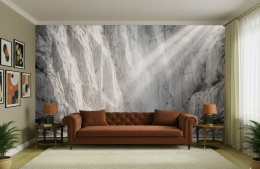 Jasna fototapeta przedstawiająca skalny kanion w świetle słonecznym nad sofą w nowoczesnym salonie.